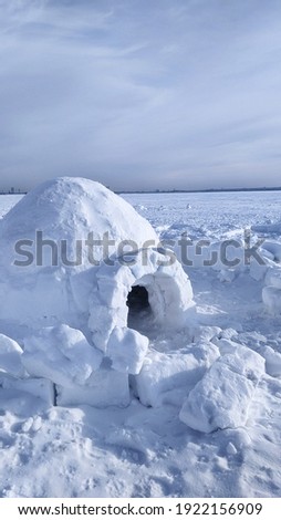 igloo and snow shelter in high snowdrift with mountains peaks on background