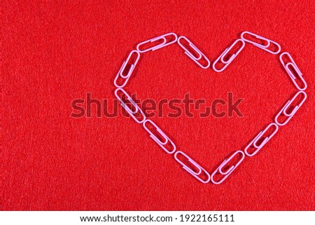 Romantic picture. Stationery romance. Heart of pink paper clips