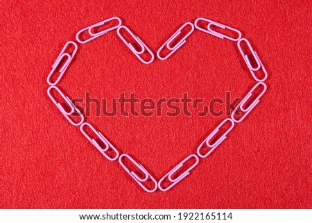 Romantic picture. Stationery romance. Heart of pink paper clips