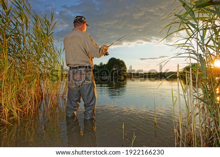 angler catching fish during summer sunset
 Royalty-Free Stock Photo #1922166230