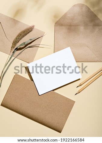 White empty card with stationery set of envelopes, notebook, pencils. Blank card styled mockup with hard light and shadow. To do list, greeting card or writing a letter concept. Royalty-Free Stock Photo #1922166584
