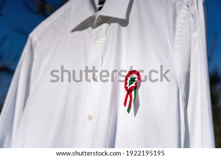 white shirt hanging outside with tricolor rosette symbol of the hungarian national day 15th of march .