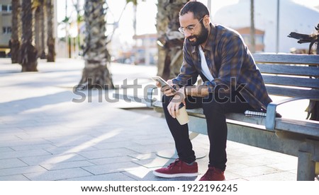 Turkish male tourist connecting to 4g in roaming for using cellular application and make online booking, man in sunglasses searching information about solo travelling via modern mobile device