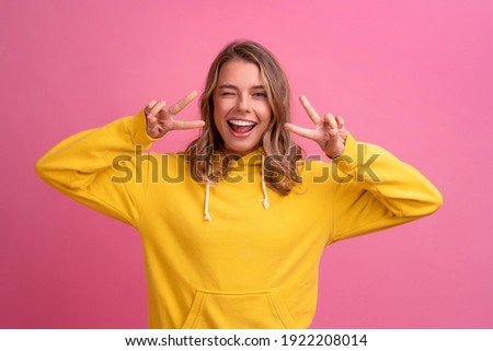 young pretty blonde woman cute face expression posing in yellow hoodie on pink bright background isolated, emotional, funny Royalty-Free Stock Photo #1922208014