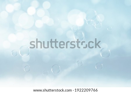 BUBBLES ON LIGHT BLUE BACKGROUND WITH BOKEH LIGHTS
