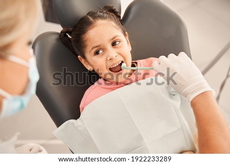 Dentist showing a girl how to brush her teeth properly.The dentist examines the child's oral cavity. Teeth brushing and treatment. Modern technologies in the field of dentistry