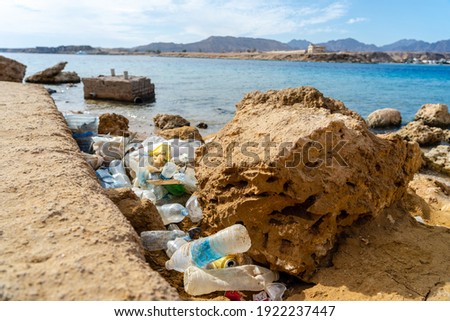Dirty plastic bottles on the beach. Ecological problem. Beach pollution