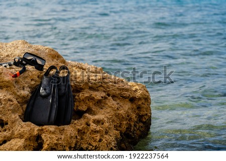 Diving mask and fins on the beach cliff