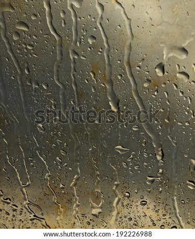 Abstract water streak pattern on a grungy stain window glass pane.