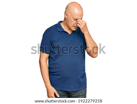 Middle age bald man wearing casual clothes tired rubbing nose and eyes feeling fatigue and headache. stress and frustration concept. 