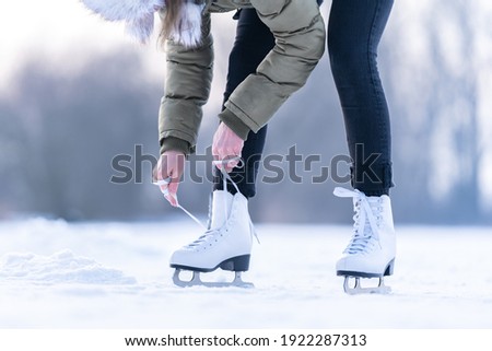 tying the laces of winter skates on a frozen lake, ice skating