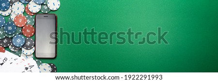 Online casino, mobile casino, mobile phone, chips cards on a green background. Gambling games. View from above.