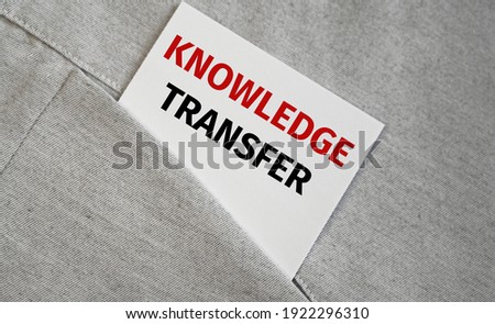 White sticker text KNOWLEDGE TRANSFER in a pocket, business concept.