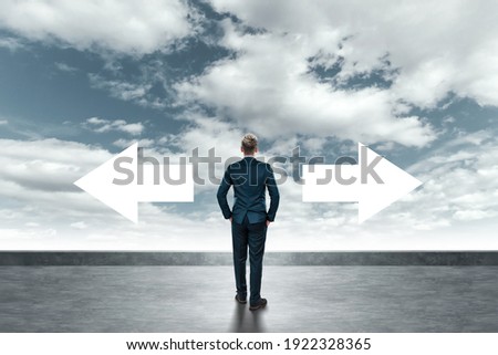 A man in a business suit stands and chooses the right path. Business concept, solution, development direction Royalty-Free Stock Photo #1922328365