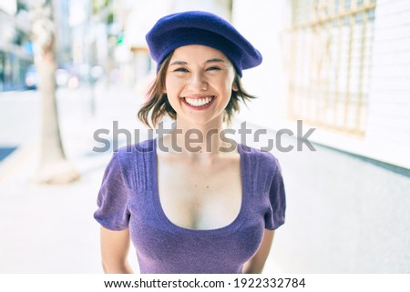 Young beautiful girl smiling happy with french style walking at street of city