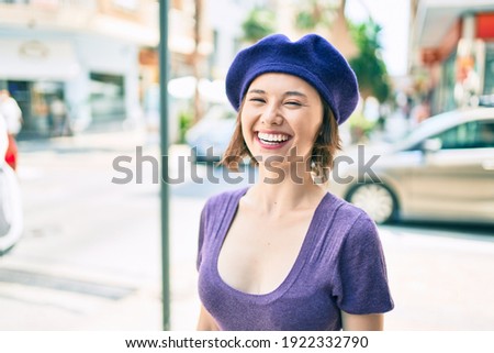 Young beautiful girl smiling happy with french style walking at street of city