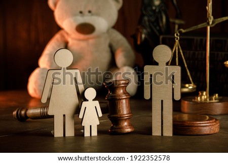 Wooden figures of family with teddy bear and gavel on a table close-up. Divorce and alimony concept Royalty-Free Stock Photo #1922352578