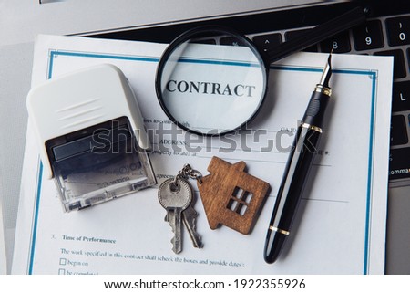 House keys, magnifying glass and contract. Concept of rent, search or mortgage house