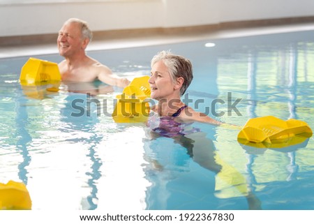 Senior women and men in Rehabilitation training in a water gymnastics class