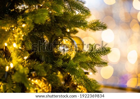 Close up of balls on christmas tree. Bokeh garlands in the background golden light holidays concepy