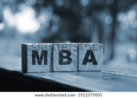 MBA written on a wooden cube in front of nature landscape. Business education concept.