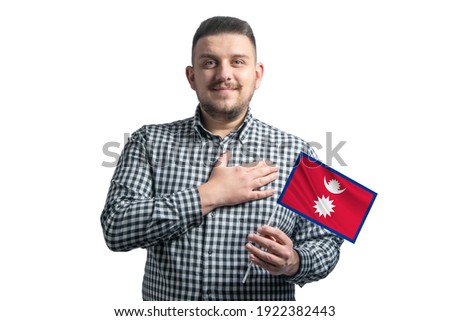 White guy holding a flag of Nepal and holds his hand on his heart isolated on a white background With love to Nepal.