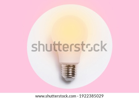 Contemporary artwork business concept. Close-up of light bulb round white frame on pink background.