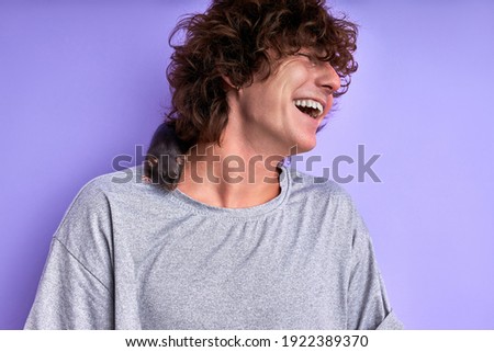 guy have fun with domestic rat , he doesn't afraid of domestic mouse, isolated on purple studio background, having fun laughing, enjoy spending time with pet at home