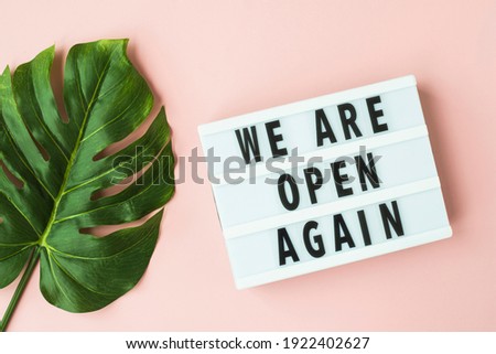 Concept of the end of quarantine. Lightbox with text message We are open on a pink background. Hotel, store, cafe, business. Notification of the end of quarantine.