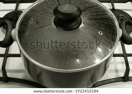 transparent glass cover on pot with boiling water on stove for home cooking Royalty-Free Stock Photo #1922410184