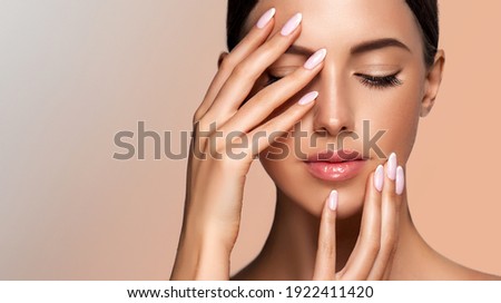 Beautiful model girl with a French manicure nails. Woman Fashion makeup and care for hands cosmetics. Facial treatment . Cosmetology,beauty and spa. Skin care Royalty-Free Stock Photo #1922411420