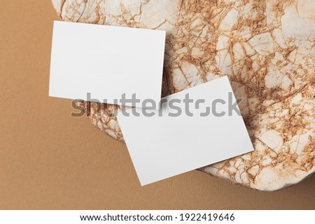 White business card mock up on the stone.