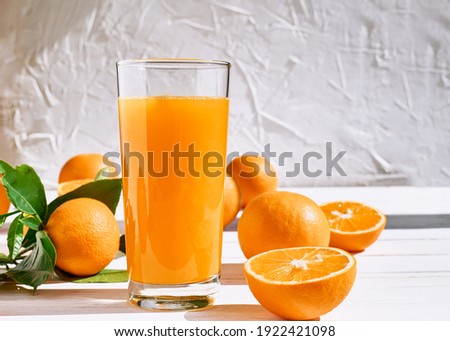 Ripe bio oranges and a glass of fresh squeezed orange juice on white wooden background. Organic Sicilian oranges Royalty-Free Stock Photo #1922421098