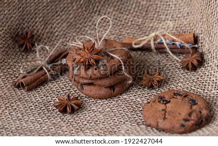 
Chocolate cookies are packed for a gift on a background of sackcloth, cinnamon and badian. Bakery products