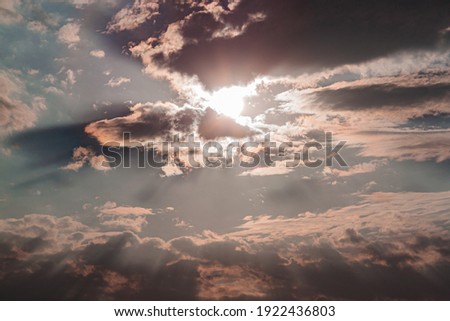 sun ray through the clouds in straight lines against the background of the sky and rain clouds during sunset, picturesque sky