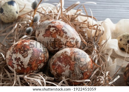 Easter composition - several marble eggs painted with natural dyes in a paper nest on the table