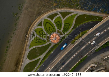 Park designed with Lotus flower pattern, Saigon River, traffic bridge, canal and main road from a top down drone shot. Graphic angle