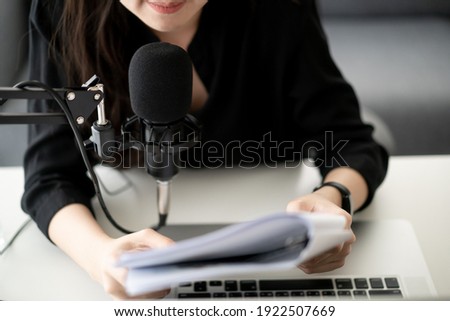 Beautiful and good looking young Asian woman arranging home podcast channel. Businesswoman recording her podcast for her online podcast live on the laptop computer and tablet. Modern working lifestyle