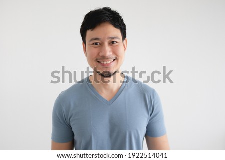 Portrait of happy Asian man in blue t-shirt on isolated white background. Royalty-Free Stock Photo #1922514041