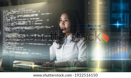 Asian Woman support desk working hard late at night over visual screen of Internet of Things Technology, Call center and customer service with technology and virtual reality concept, 