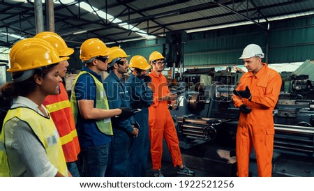 Skillful worker attending brief meeting in the factory . Industrial people and manufacturing labor concept . Royalty-Free Stock Photo #1922521256