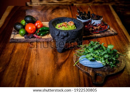 Guacamole dip in lava rock bowl with fresh ingredients