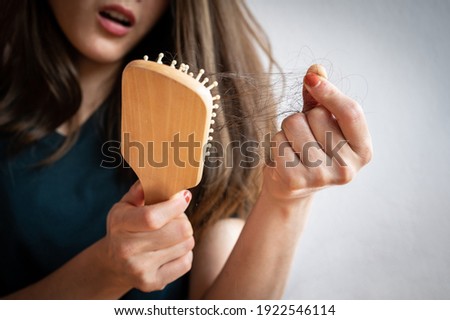 Close-up of worried woman holding comb with hair loss after brushing her hair. Hair loss it cause from family history, hormonal changes, unhealthy of aging. Royalty-Free Stock Photo #1922546114