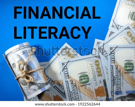 Selective focus.Word FINANCIAL LITERACY with dollar banknote on blue background.Business concept.Shot were noise and film grain.
