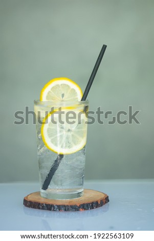 Ice cold spring water with slices of lemons and straw.