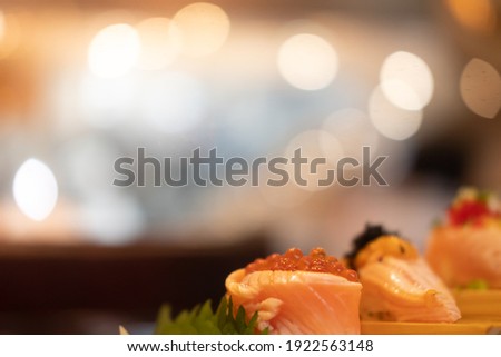 Selective focus on rolls salmon topped with salmon roe against bokeh background