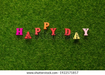Happy day text on a green grass. 
