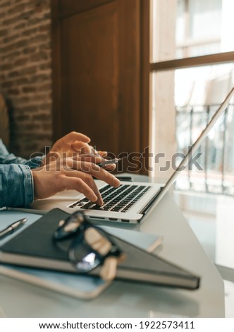 Close-up photo of male hands with laptop. Man is working remotely from home. Freelancer at work