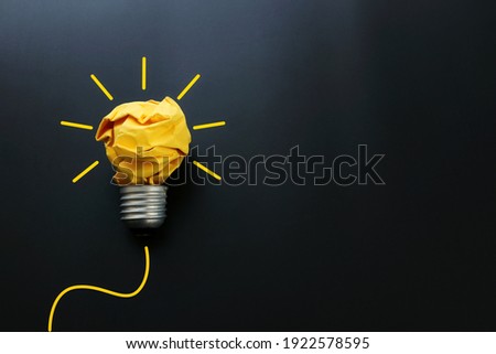 Education concept image. Creative idea and innovation. Crumpled paper as light bulb metaphor over black background Royalty-Free Stock Photo #1922578595