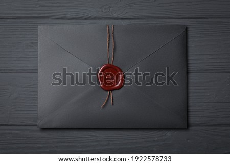 Envelope with wax seal on black wooden background, top view Royalty-Free Stock Photo #1922578733